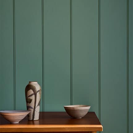 Ruhiges Homeoffice mit Wandvertäfelung in Perpetual Blue. Das gedämpfte Blau wird durch Deckenbalken in Bronze Red und den warmen Farbton Oak Apple ergänzt.